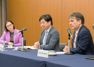Three people in a discussion at a table.