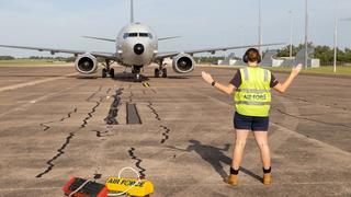 A Royal Australian Air Force aviator marshals an Indian Navy P-8I Neptune maritime patrol aircraft to a stop at RAAF Base Darwin, April 2022