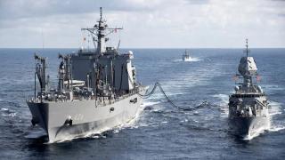 JS Oumi and HMAS Arunta conduct a replenishment at sea as INS Kamorta sails into formation during Exercise Malabar 2022