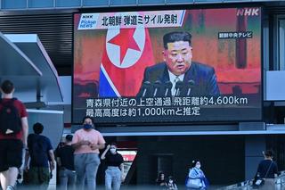 Pedestrians in Tokyo walk under a large screen showing images of North Korea’s leader Kim Jong Un after North Korea launched a missile that prompted an evacuation alert when it flew over northeastern Japan, October 2022